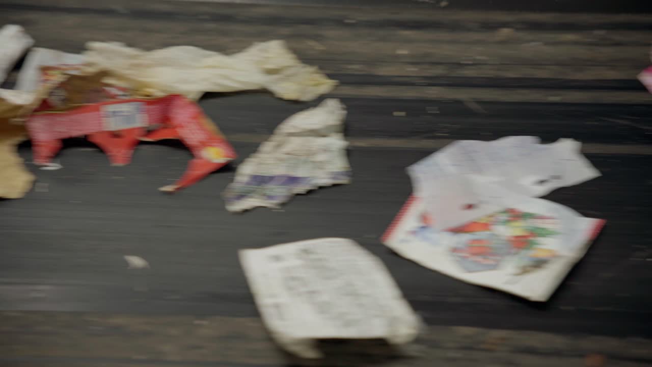 컨베이어 벨트를 분류하고 쓰레기 재료, 주로 종이와 플라스틱을 처리합니다.