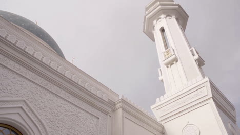 exterior of a white mosque with minaret and dome