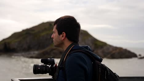 Männlicher-Fotograf-Bewundert-Die-Landschaft-In-Bracelet-Bay-Vom-Mumbles-Pier-Aus