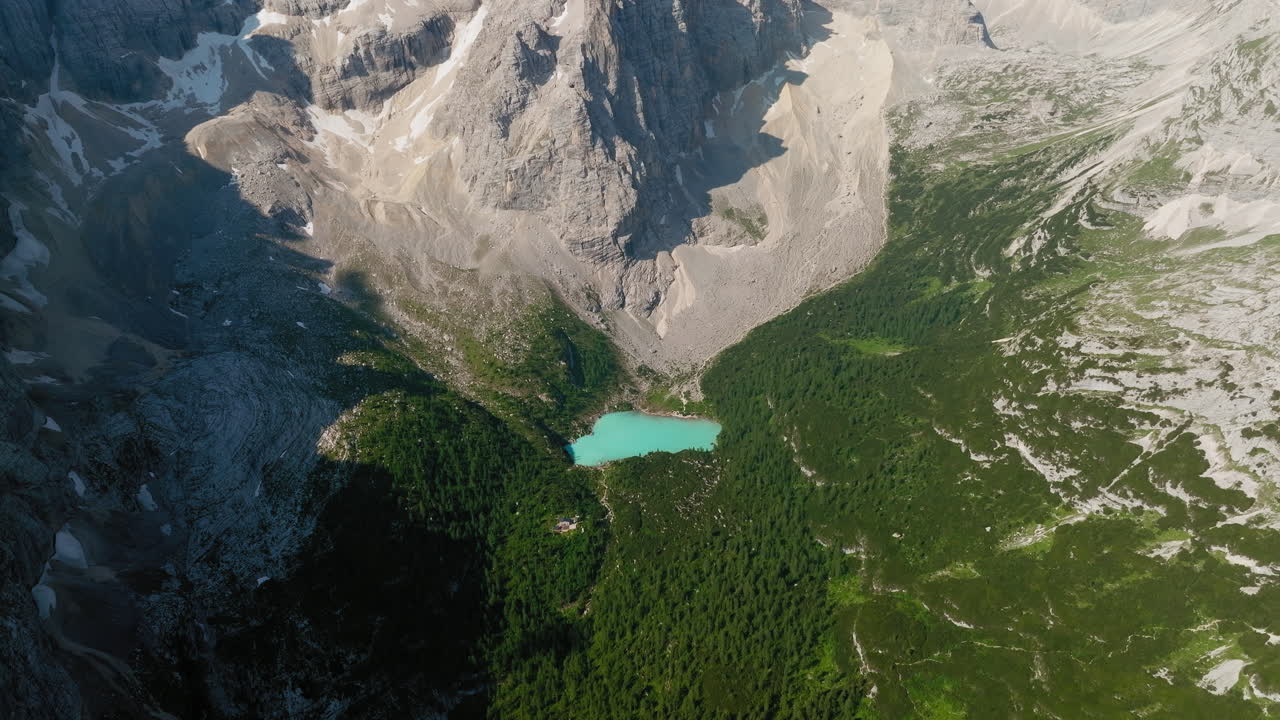 Drone shot of Lake Sorapis with emerald crystal clear water during spring, Dolomites, Italy