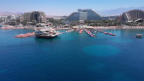 aerial view of eilat resort city coastline with hotels, beach, and paddle boats on the red sea