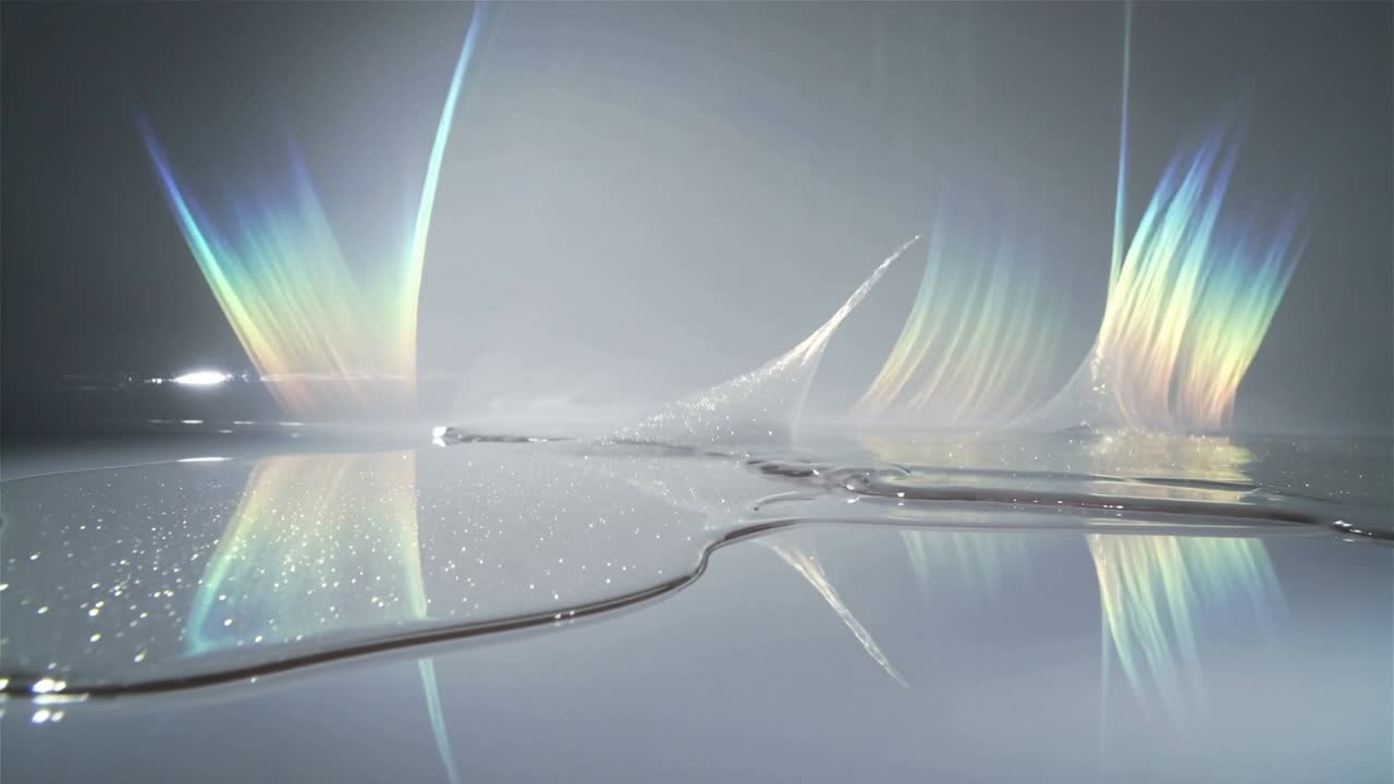 Clear puddle spreading on mirror panel, off-frame light shifting and forming prism glow for design
