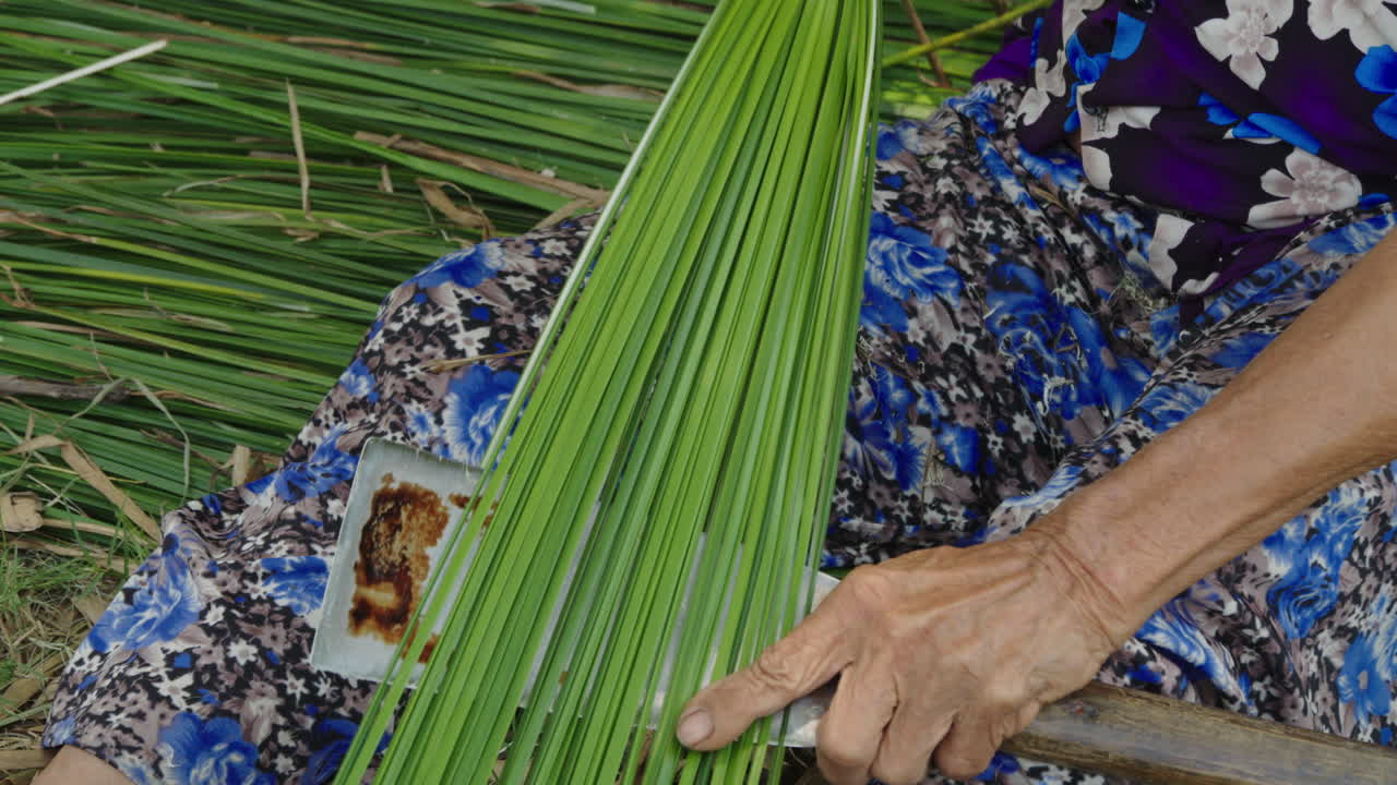 close view of artisan hands using natural materials to craft traditional mattresses, preserving the legacy of her community's heritage with each expertly made piece, Quang Nam, Vietnam,