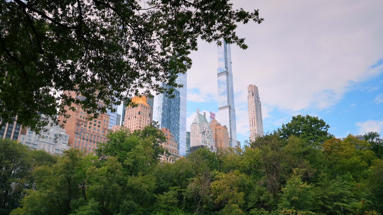 New York, USA, 4 August 2025: New York skyline framed by Central Park trees. Skyscrapers peek above leafy Central Park canopy