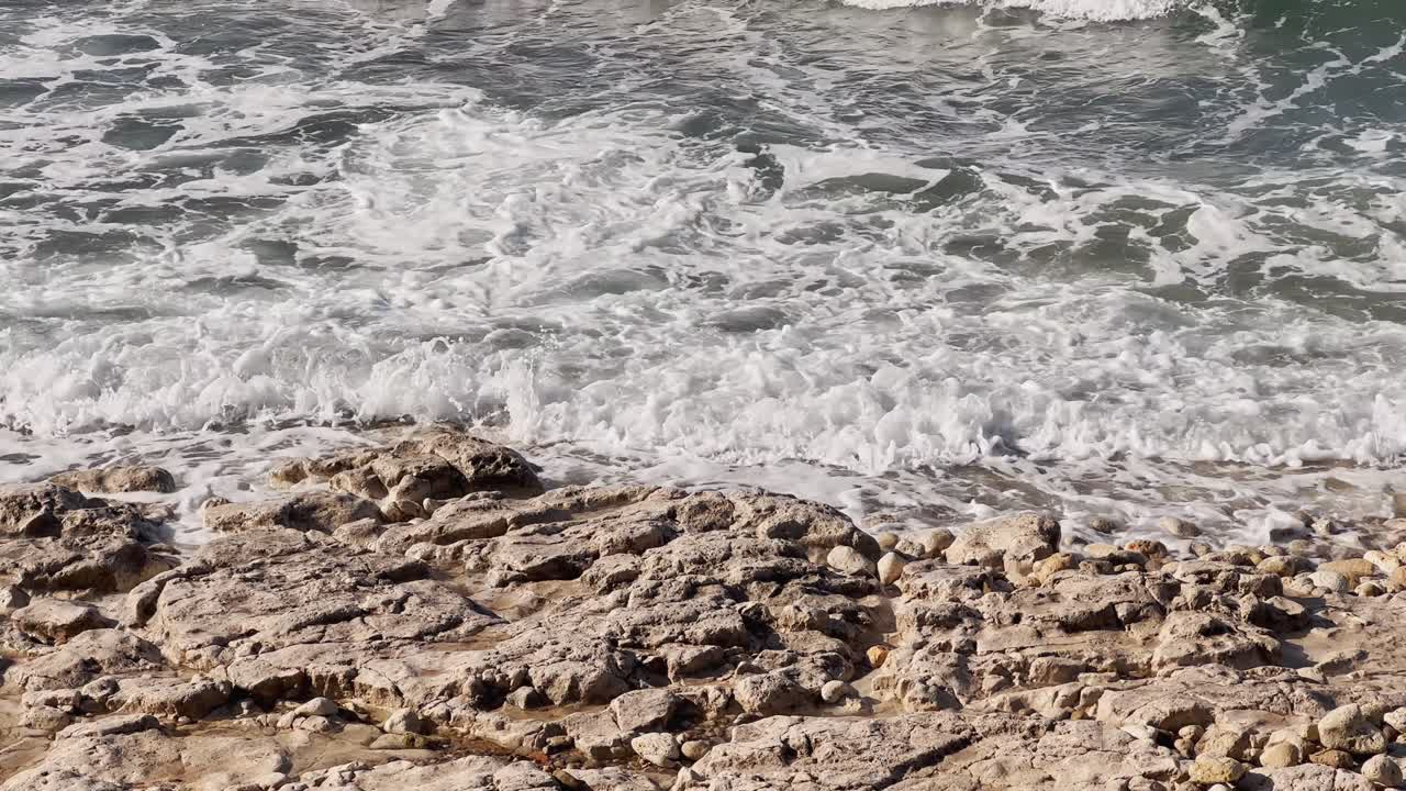 영화 속의 바다와 바다의 파도가 모래를 가로질러 미끄러진다.