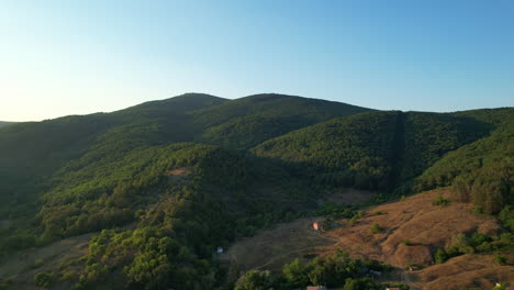 drone shot over bulgarian village into hills and woods 02
