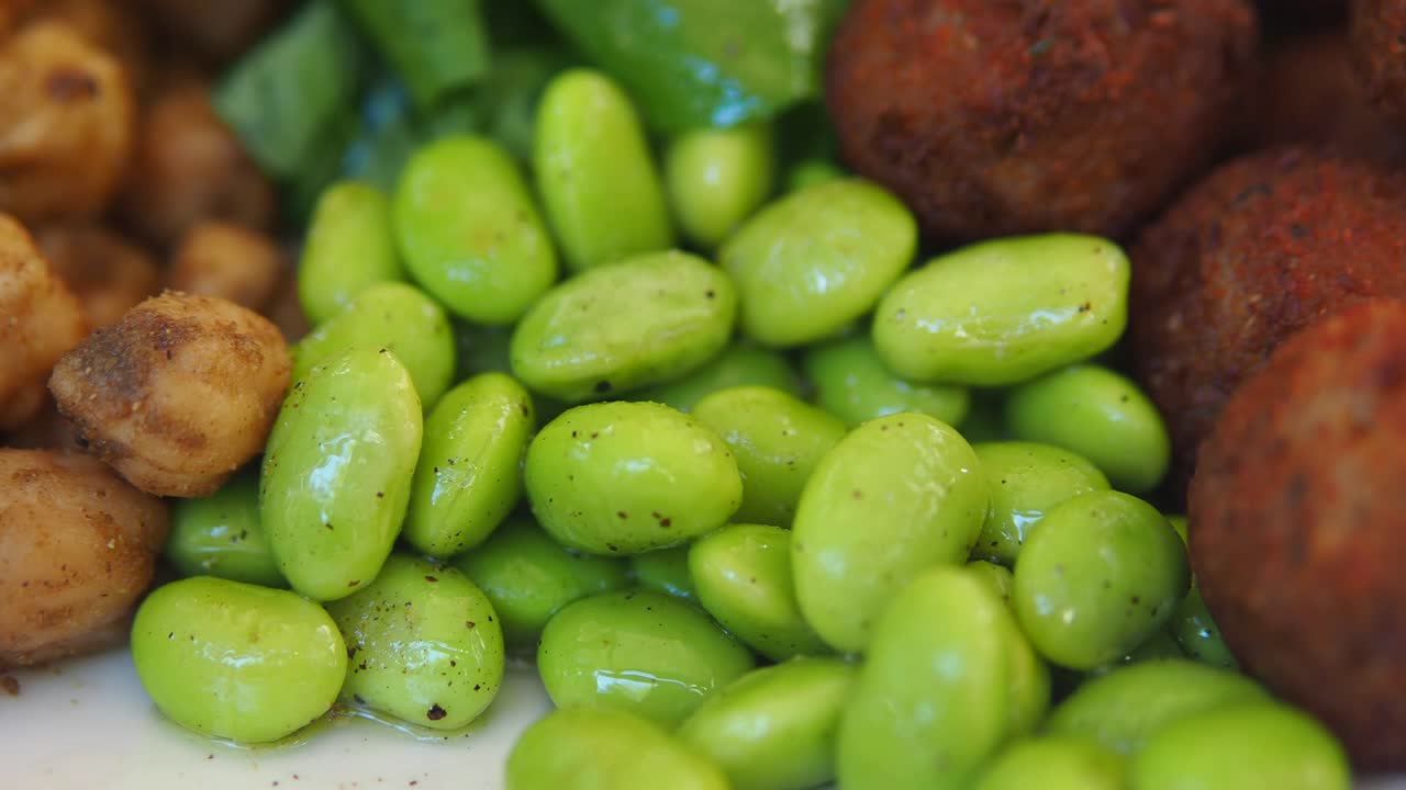 Primer plano de edamame, garbanzos y falafel.
