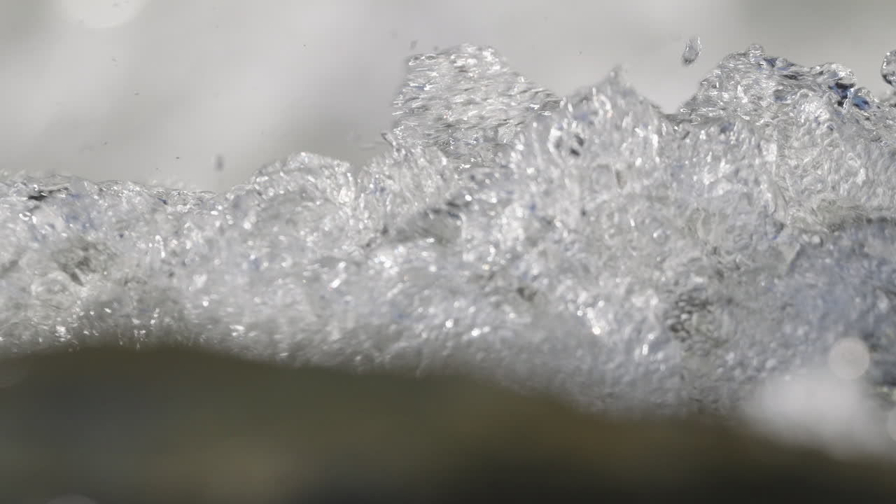 Acqua in un fiume che si muove velocemente al rallentatore e macro