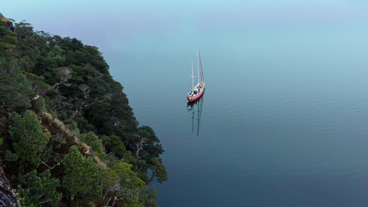 Boat Sailing Near Steep Forest Mountain In Beagle Channel Strait In Tierra del Fuego, South America. Aerial Drone Shot