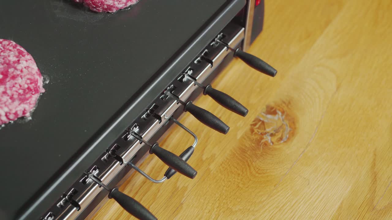 Plancha grill on countertop, mouthwatering burgers searing. Static closeup