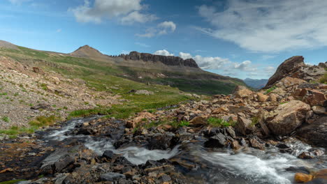 timelapse, nubes moviéndose sobre el paisaje montañoso y el arroyo
