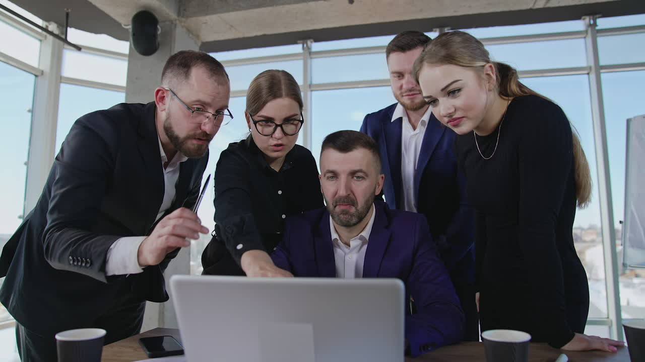 Office team stand near boss and his laptop and offer ideas. Brainstorming and ideas sharing for better results in work. Panoramic windows with cityscape at the backdrop.