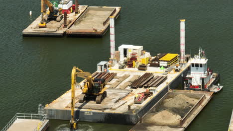 excavator removing sand dredging the mississippi river, telephoto shot