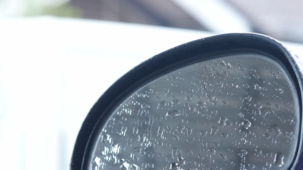 primo piano dello specchietto retrovisore di una moto bagnato dall'acqua piovana