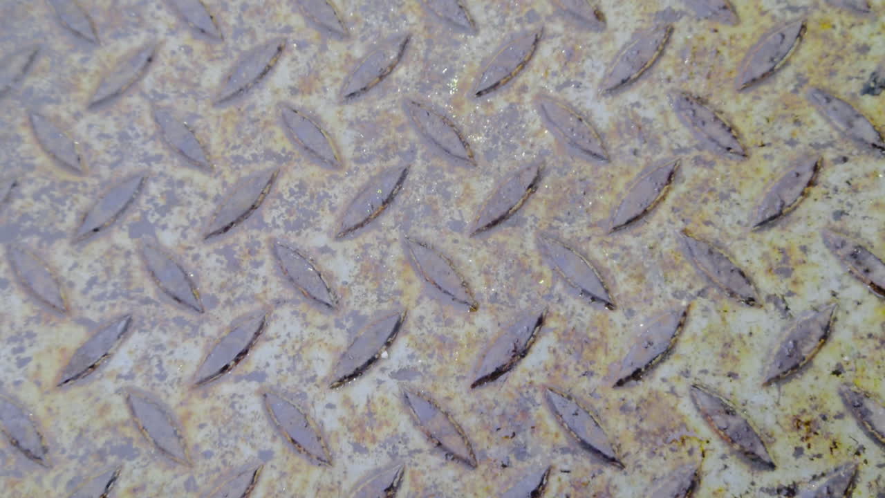 Superficie metallica invecchiata con graffi sottili e detriti industriali trovati su un pavimento in lamiera striata a Zuglo, Budapest. Texture ad alta risoluzione per ambienti digitali realistici del 2026 e design VR