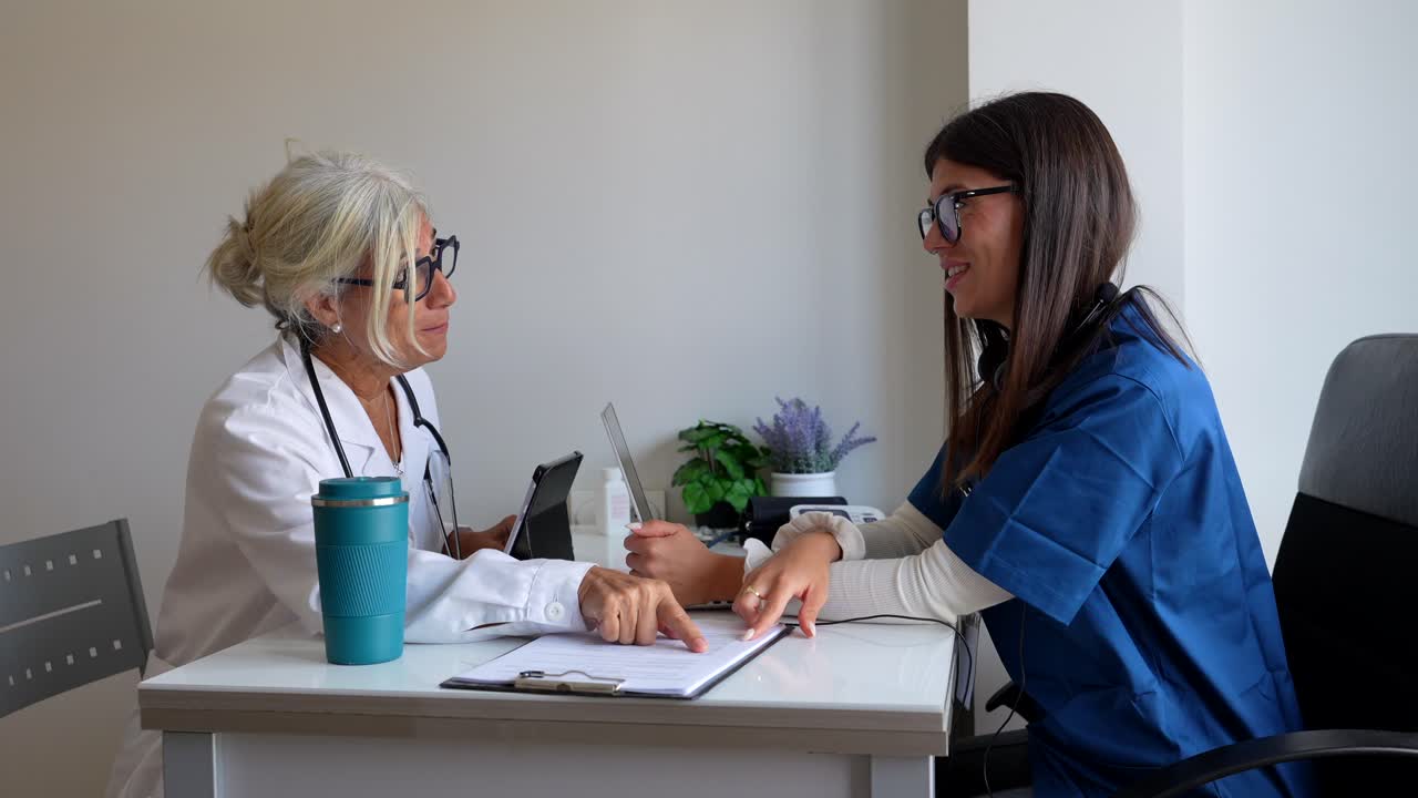 Two female healthcare professionals discussing a case in an office