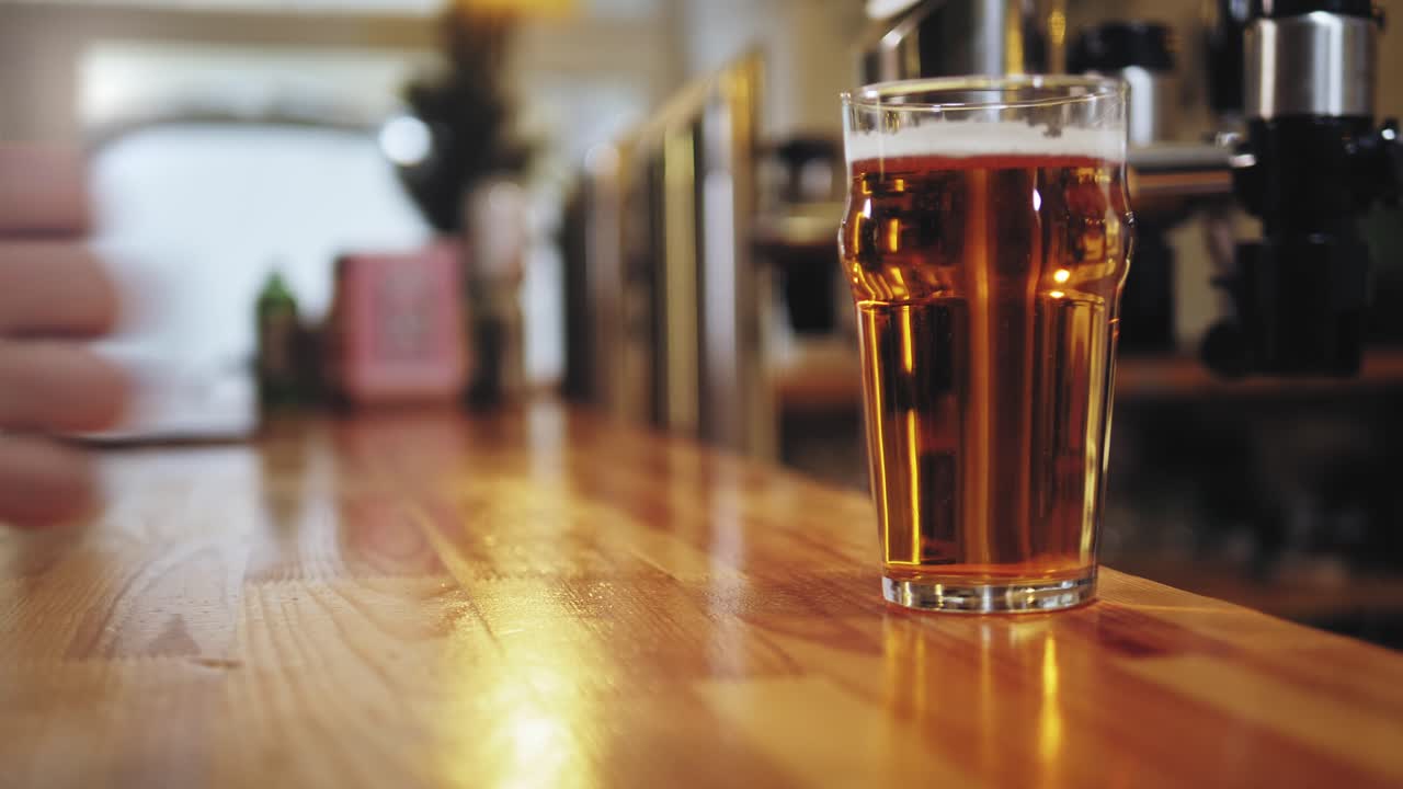 Cliente che effettua un pagamento contactless per una birra al bar