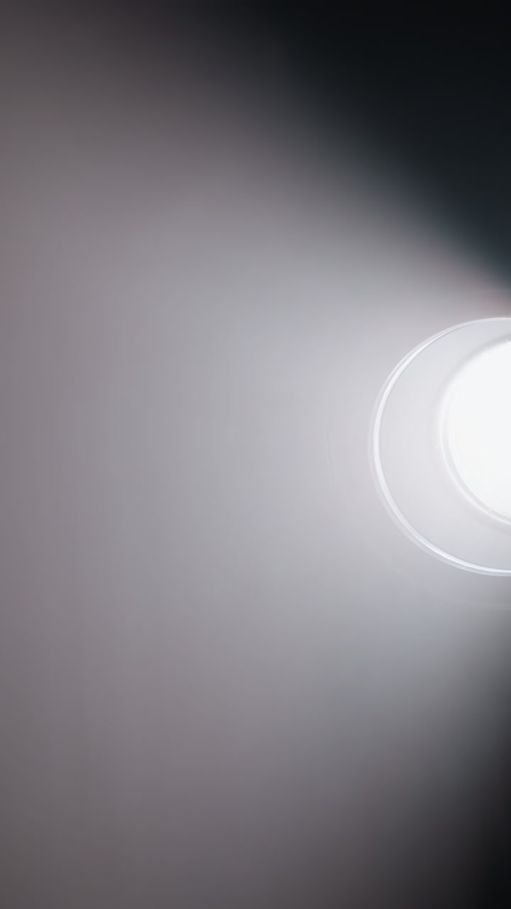 스튜디오 스포트라이트 (studio spotlight) 는 어두운 방을 가로질러 강한 빛의 을 던지고, 연기와 대기를 강조합니다.