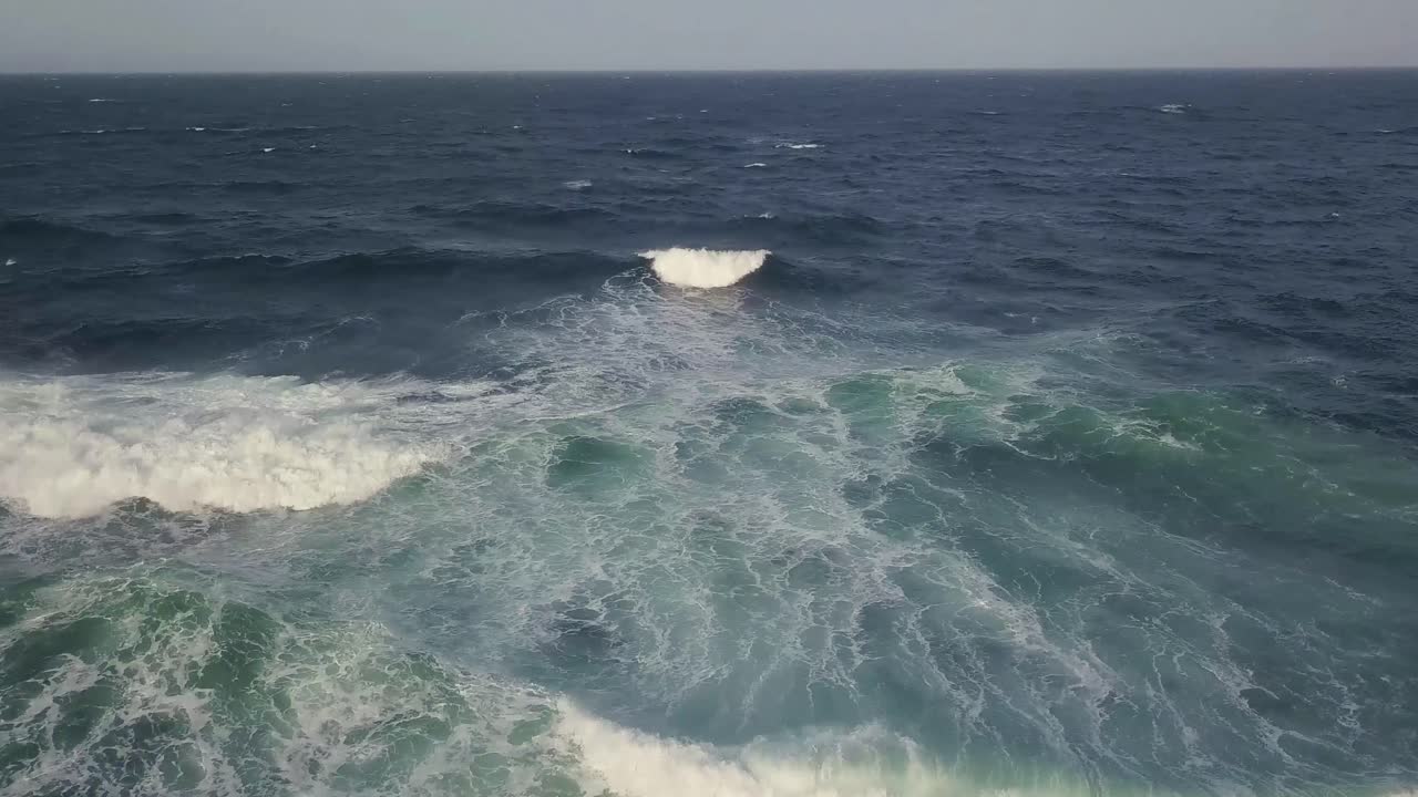 Drone flying over breaking waves on a misty day, NSW coast Australia