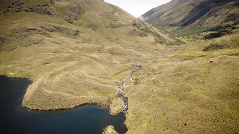 drone flying over andes mountains and lake in parque nacional cajas, ecuador