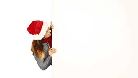 Beauty-brunette-in-santa-hat-pointing-white-poster