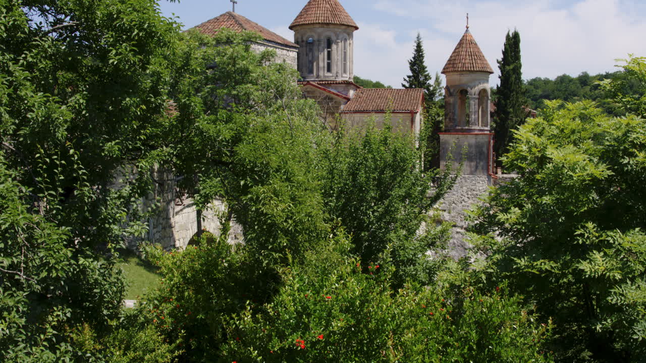 monasterio de motsameta rodeado de arbustos y árboles en un día soleado