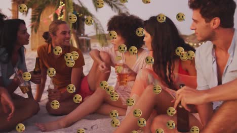 multiple face emojis floating against group of friends having drinks on the beach