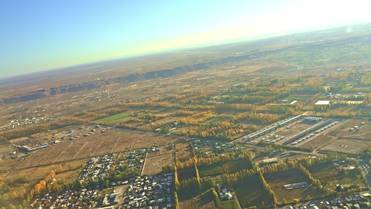 秋の木々と農地が広がる田園風景の空撮