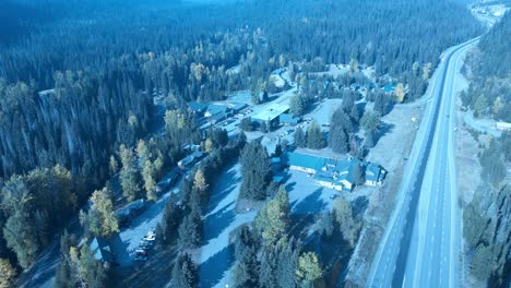 Manning-Park-main-entrance-aerial-birds-top-view-flyover-overlooking-property-next-to-the-highway-entrance-to-the-main-hotel,-rental-chalets,-cabins,-banquet-halls,-pubs-and-restaurants-onsite-2-3