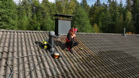 aerial view of a woman wearing a harness for private house roof cleaning