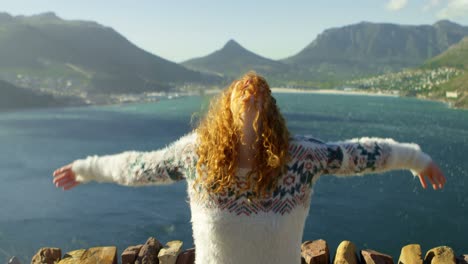 woman standing with arms outstretched near a sea 4k