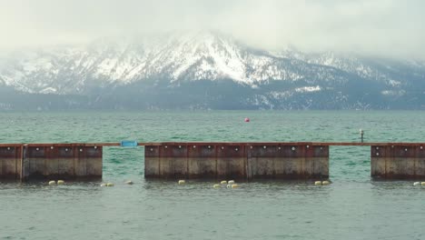 south lake tahoe durante el invierno con un muelle en el medio y hermosas montañas cubiertas de nieve en el fondo