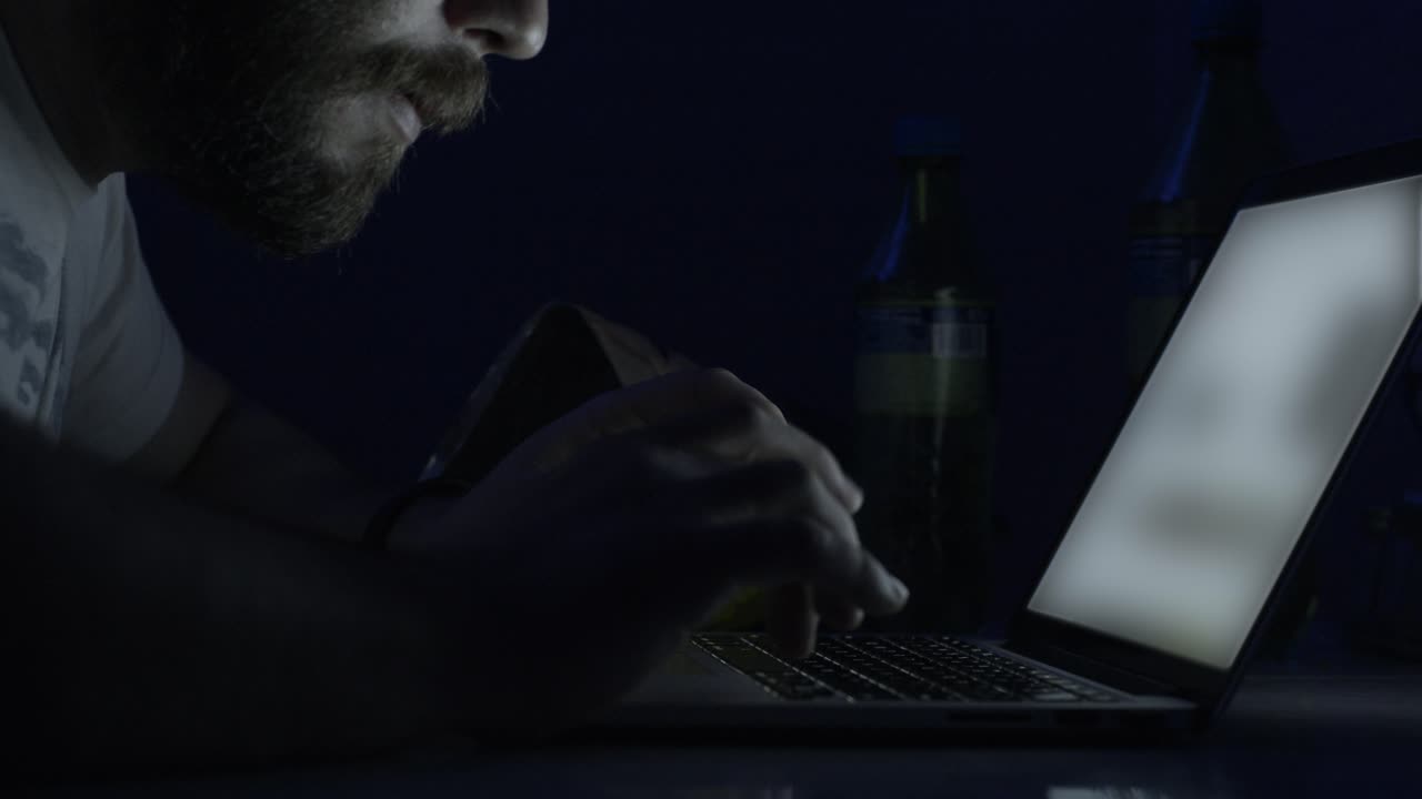 hombre trabajando tarde en la noche en una computadora portátil