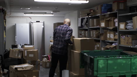 Adult-Ethnic-Minority-Male-Searching-In-Basement-Past-Boxes