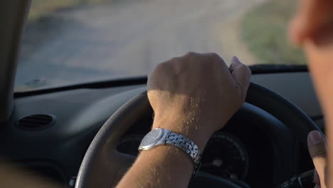 hands of man driving a car