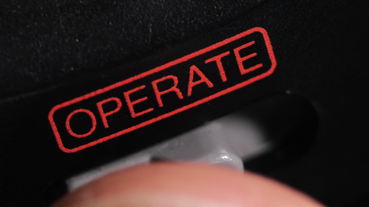 Macro close up of operate switch turned on with red label on black camera body