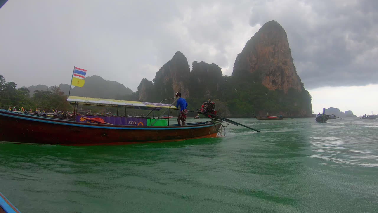 SLOW MOTION | A boat in Thailand leaving the beach and trying to beat the approaching storm. Islands and other boats in the background