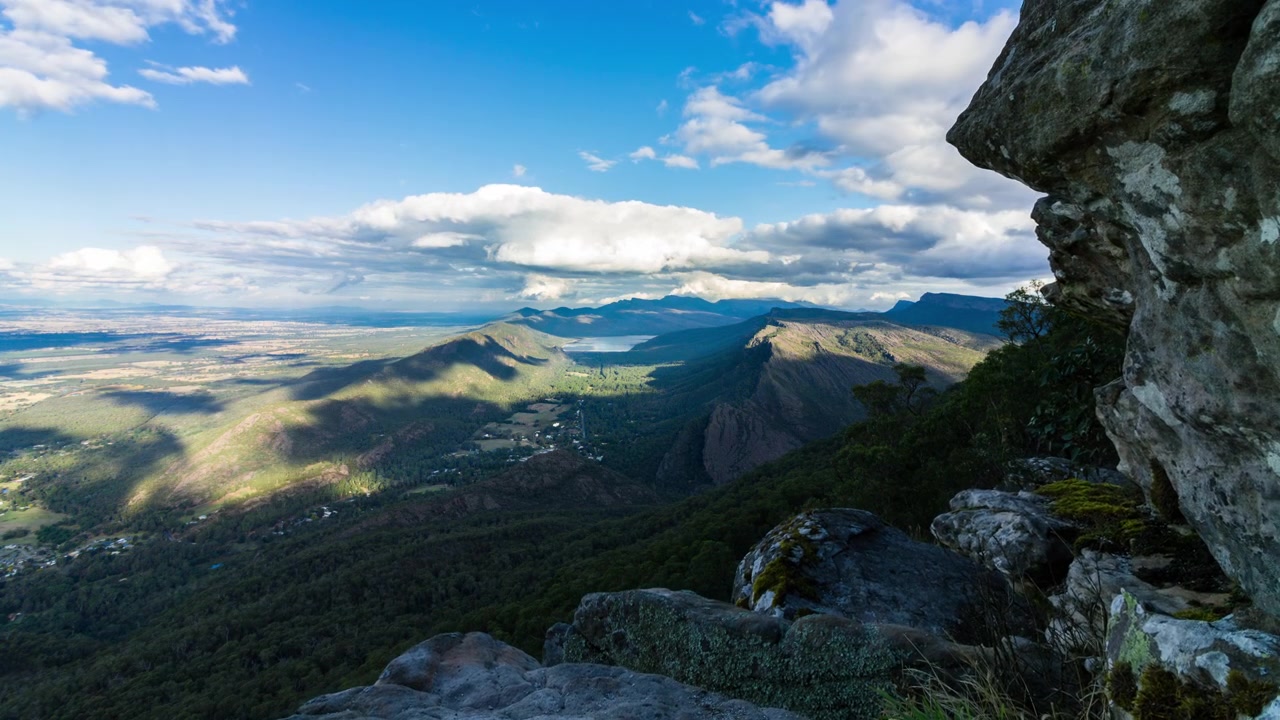 Timelapse de nubes formándose sobre Halls Gap mientras un afloramiento rocoso cubierto de musgo se revela en el Mirador Boroka en el Parque Nacional Grampians, Victoria (Australia)