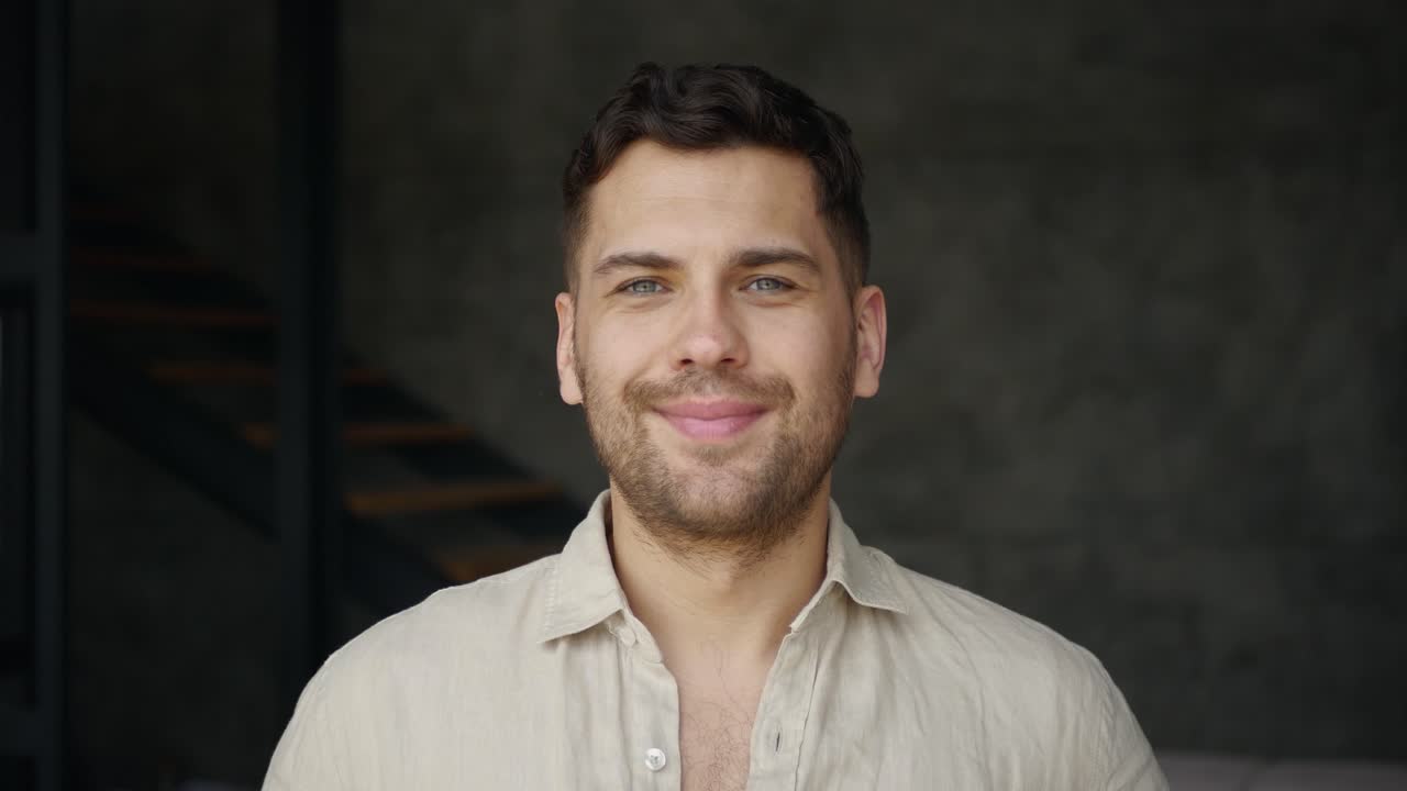 Young Man Smiling And Laughing, Looking At Camera Indoors
