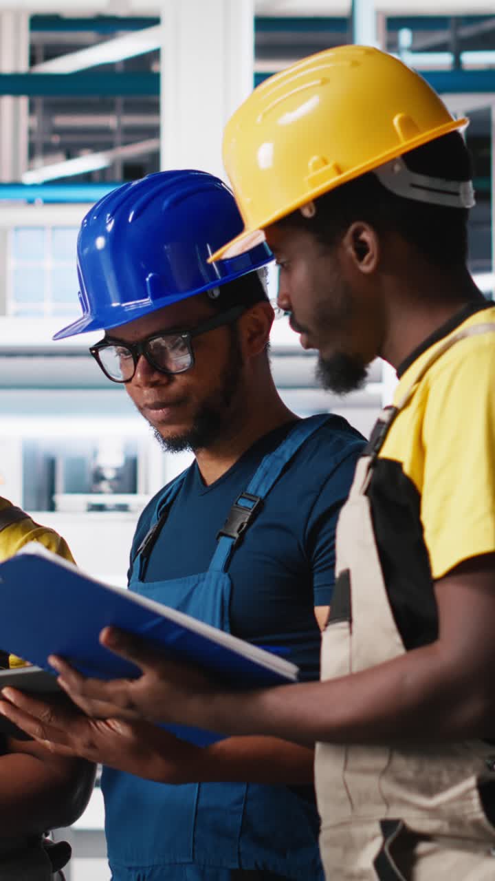 Vertical Video Group of black employees at the solar panels factory reviewing data