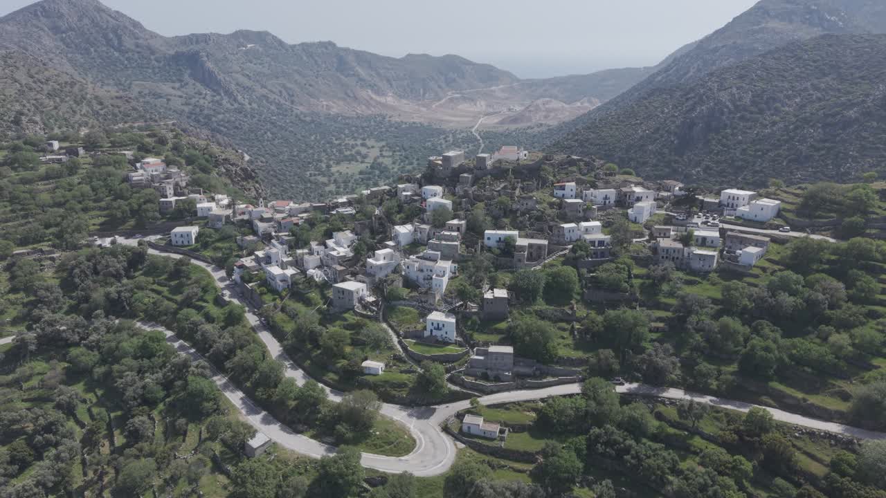 Aerial drone footage of Emporeios village revealing volcanic caldera behind it. Tight shot filmed with 3x telephoto lens in D-Log M profile
