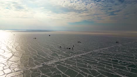 Menschen,-Die-Auf-Zugefrorenem-See-Angeln-Und-Spazieren-Gehen,-Mit-Blauem-Himmel-Und-Eisiger-Textur,-Lake-St-Clair-60fps-Luftdrohnenaufnahme