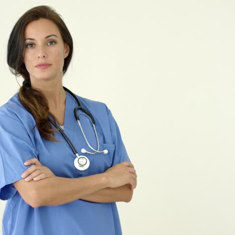 Woman-in-scrubs-crosses-arms-and-smiles-at-camera