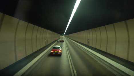 bus driving through a two-way tunnel with light on the top