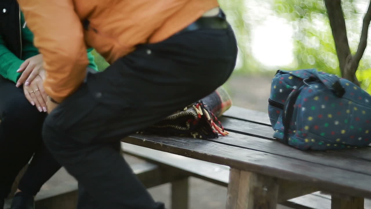 Beautiful young couple sitting on a bench in the park
