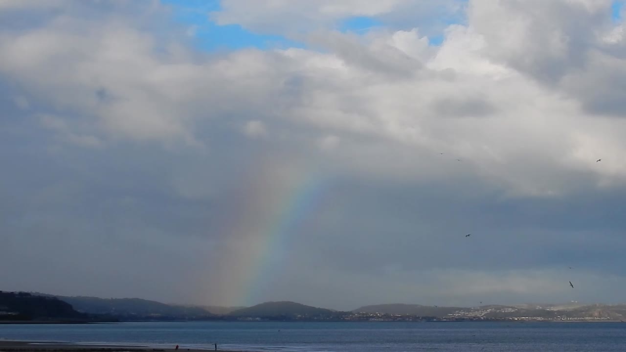 arco iris colorido escénico sobre las montañas galesas paisaje marino costero horizonte