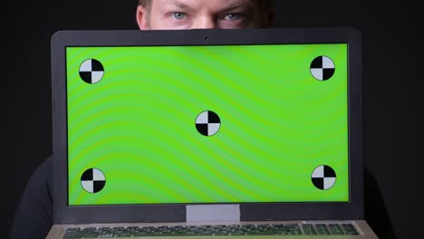 man holding laptop with chroma key green screen