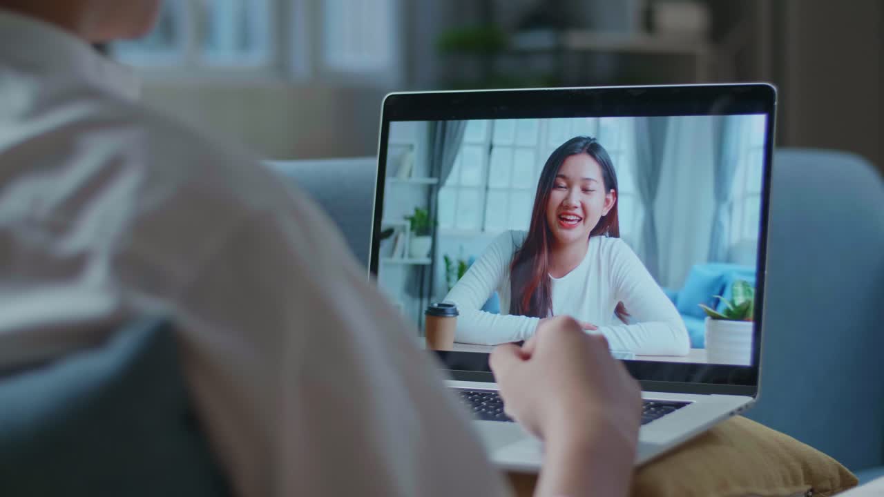 Close Up Of A Man Having Video Call With A Woman On Laptop While Lying On Sofa In The Living Room