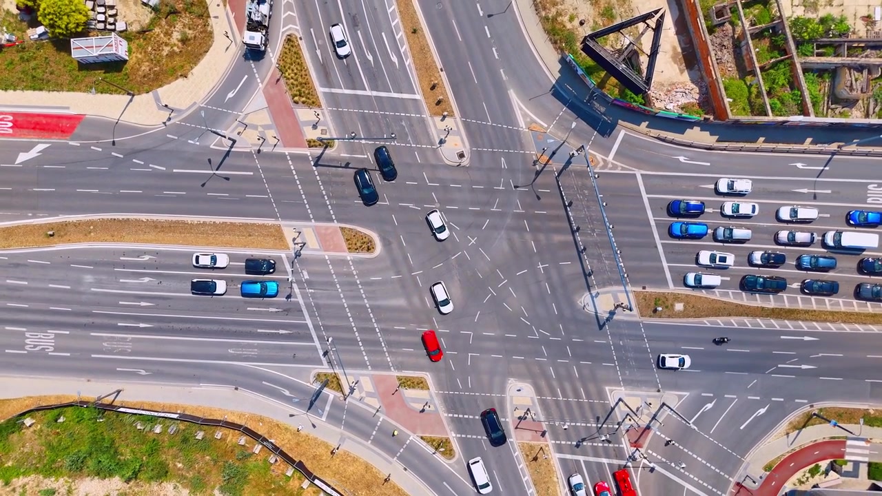 Overhead drone view of a city crossroad, Bratislava, Slovakia. High angle shot looking down at traffic lanes with multiple colored vehicles driving.