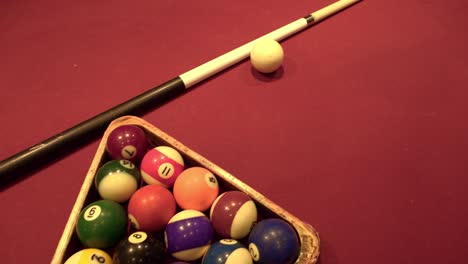 old billiard balls, cue and triangle on red carpet